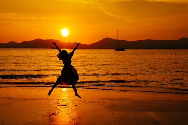 Foto relax donna saltando mare sulla spiaggia