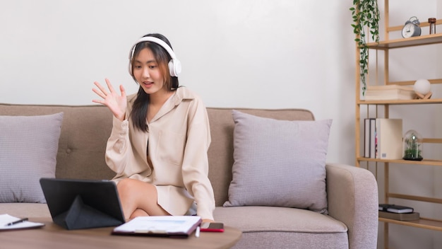 Photo relaxation lifestyle concept young asian woman doing greeting gesture with friend on video call