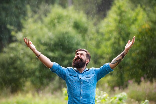 リラクゼーションと前向きな思考嵐の天気雨の下でひげを生やした男秋の雨