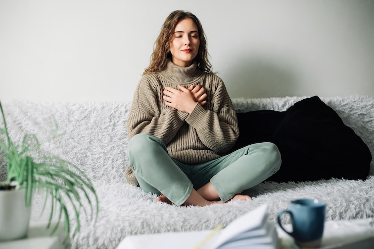 Photo relaxation techniques woman practicing pranayama in lotus position on bed breathing exercises
