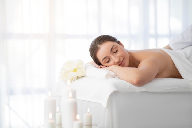 Relaxation and wellness young woman lying on massage table in spa salon