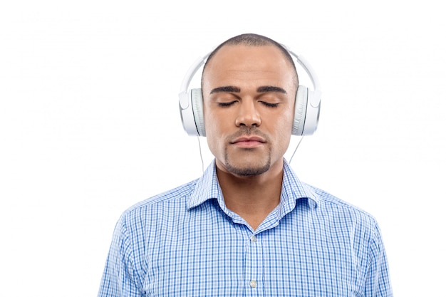 Relaxed afro man listening to music with his headphones isolated 