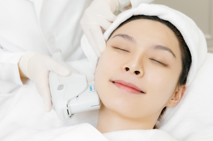 舒適的亞洲女人在美容院接受美容師的面部皮膚超聲波空洞和抗衰老 面部治療美容注射程序為皮膚護理 近距離美容師手