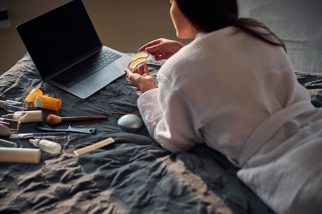 Photo relaxed brunette female staring at her laptop