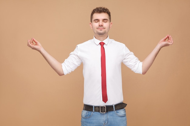 Uomo d'affari rilassato che fa pose di yoga