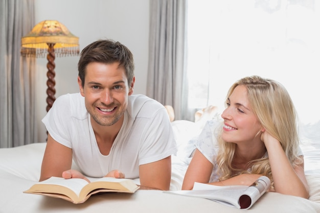 Photo relaxed casual couple reading books in bed