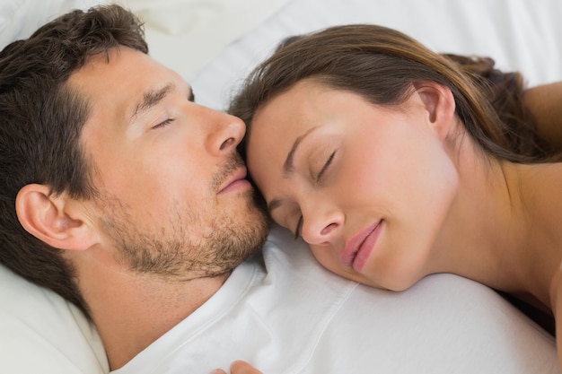 Relaxed couple sleeping together in bed