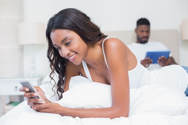 Relaxed couple using technology on bed