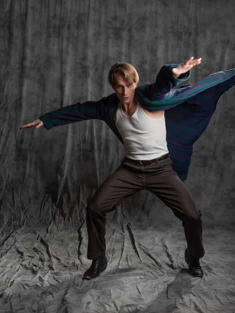 Relaxed dude after a party in a housecoat with a shaggy head makes funny drunk poses in the studio o