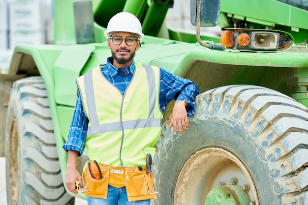 Photo relaxed engineer near heavy machine