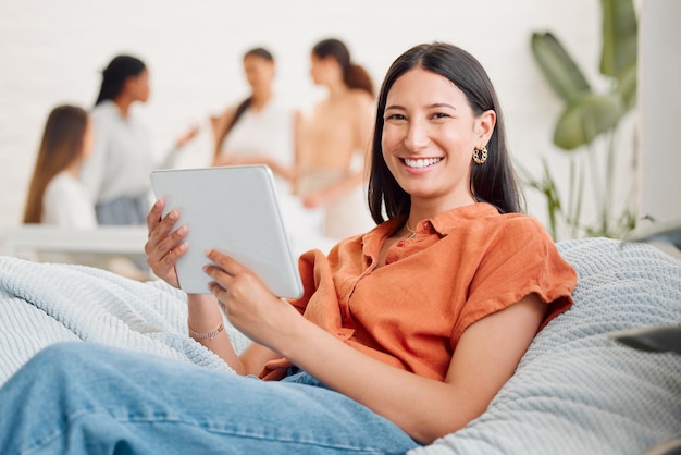 Relaxed happy and relaxing digital marketing agency employee on a break browsing the internet on a tablet Portrait of a smiling young and excited female worker searching for social media trends