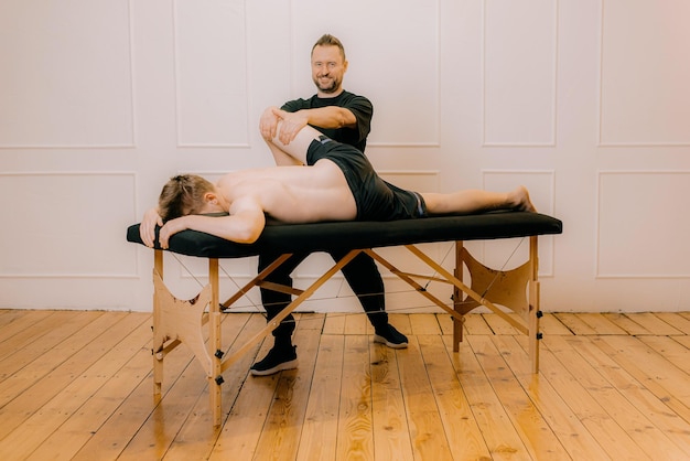 Relaxed man getting back massage with professional chiropractor relaxation concept manual therapy
