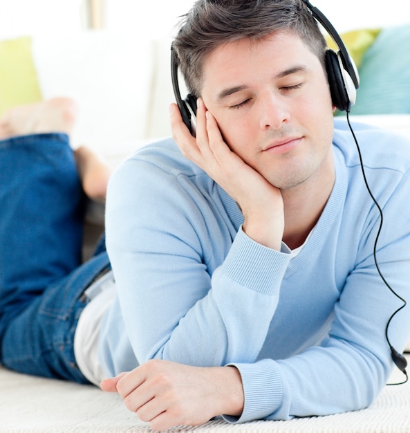 Relaxed man lying on the floor listening to music