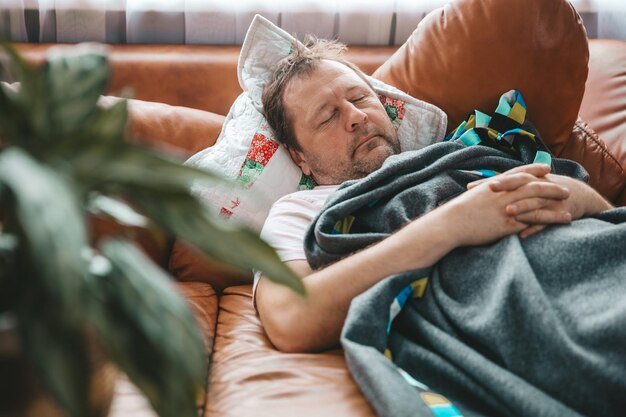 Photo relaxed man resting on a couch at home