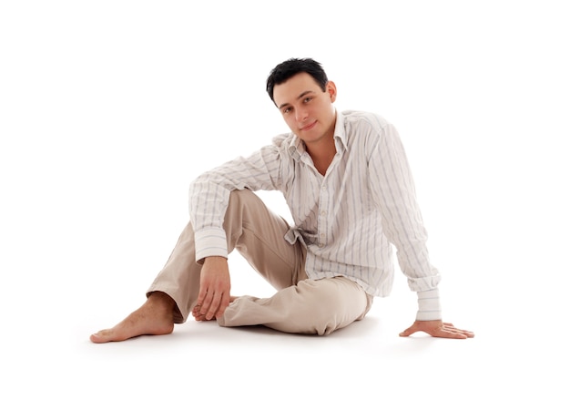 relaxed man sitting on the floor over white