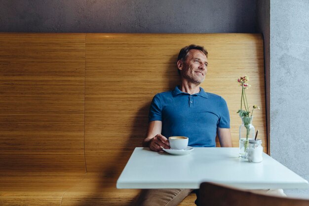 Relaxed mature man sitting in cafe