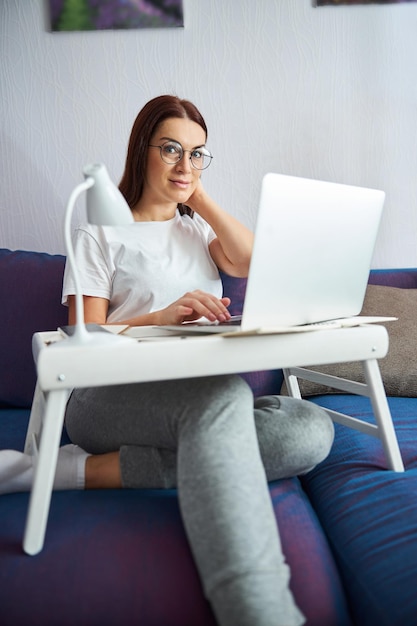 Relaxed pretty woman enjoying working online from home