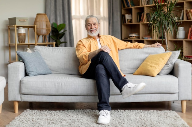 Relaxed senior man sitting on couch at home