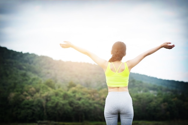 Relaxed woman breathing fresh air raising arms.