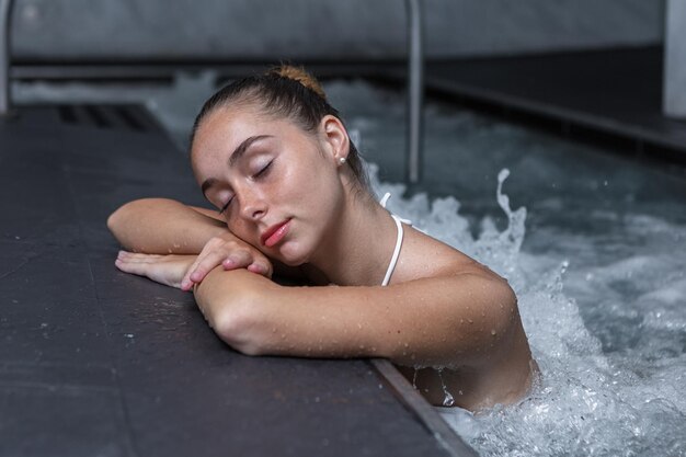 Фото Расслабленная женщина во время гидротерапии в бассейне
