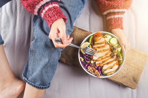 Donna rilassata che gode dell'insalata del petto di pollo a casa