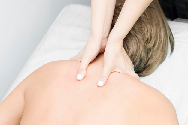 A relaxed woman getting a neck massage at a wellness center