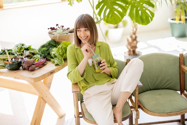 Photo relaxed woman with healthy food in the room with plants