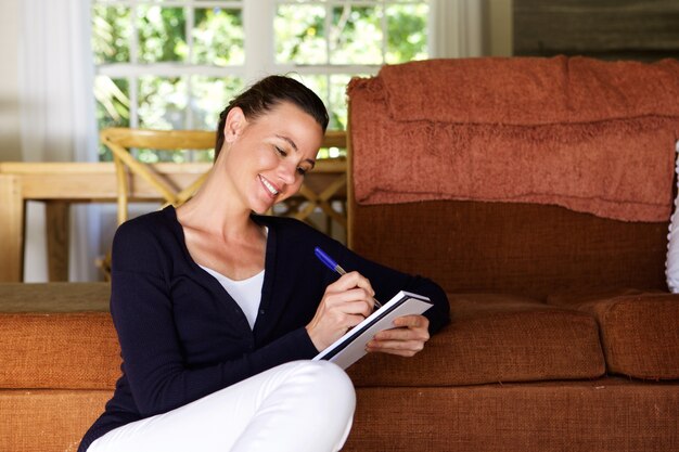 Relaxed woman writing in notebook at home