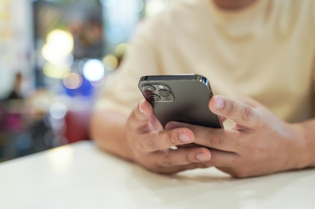 Relaxed young asian man using smart phone spending time checking news social media