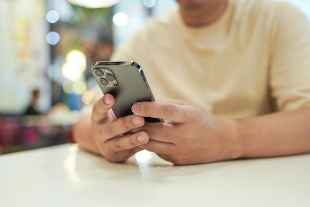 뉴스 소셜 미디어를 확인하는 데 시간을 보내는 스마트 폰을 사용하여 편안한 젊은 아시아 남자