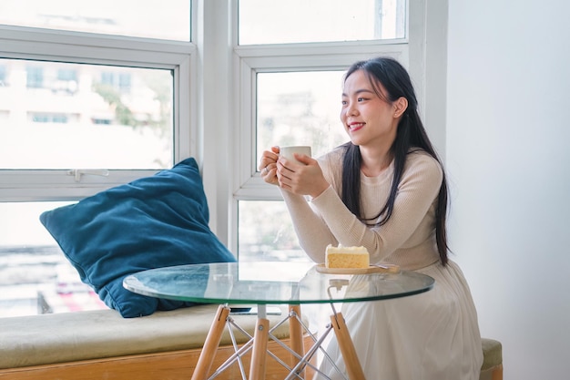 Relaxed young asian woman drink coffee while sitting in a cafe
