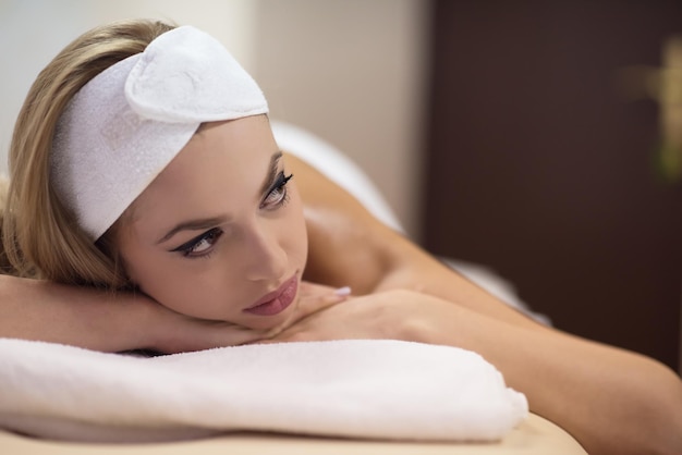 Relaxed young beautiful  woman laying on massage table