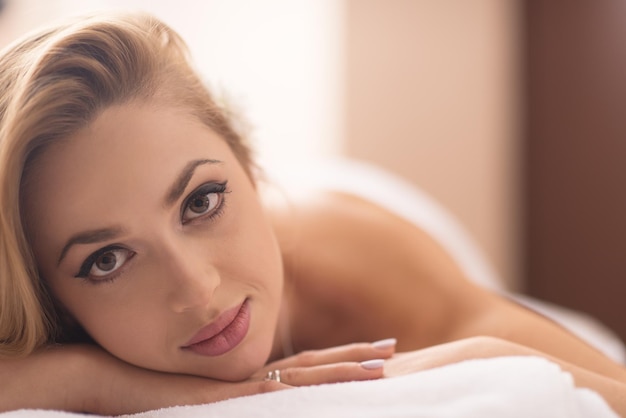 Relaxed young beautiful  woman laying on massage table