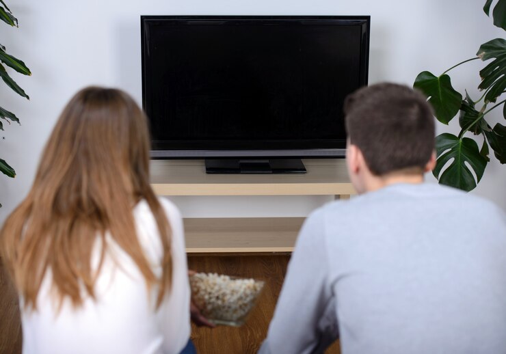 Photo 一緒にテレビを見てリラックスした若いカップル。