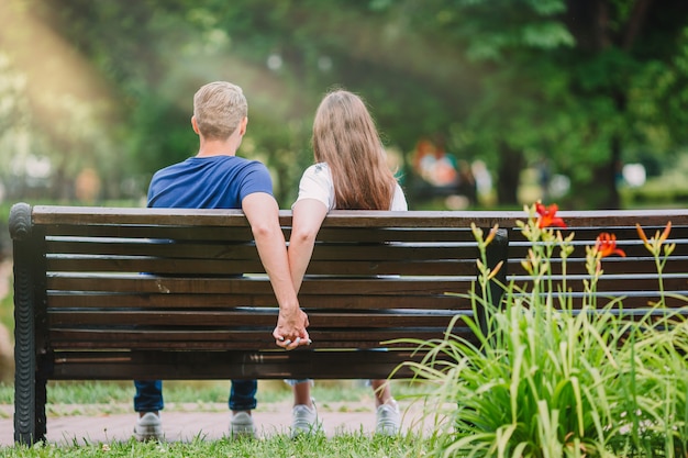 Relaxed young family on the bench in the park