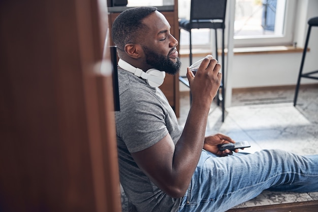 Relaxed young male person enjoying tasty coffee