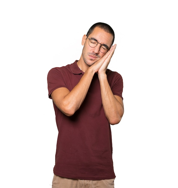 Relaxed young man making a gesture of sleep