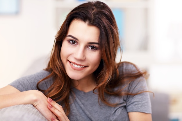 relaxed young woman enjoying rest on comfortable sofa