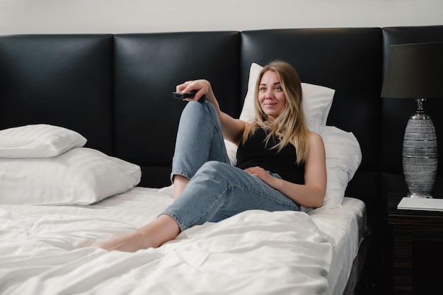 Relaxed young woman in hotel room bed having rest