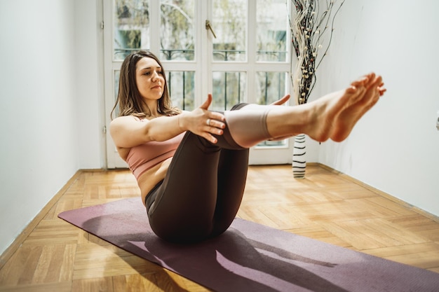 Relaxed young woman practicing yoga at home.