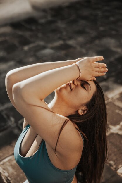 Relaxed young woman practicing yoga on a rooftop terrace.