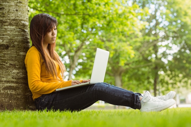 Relaxed young woman using laptop in park