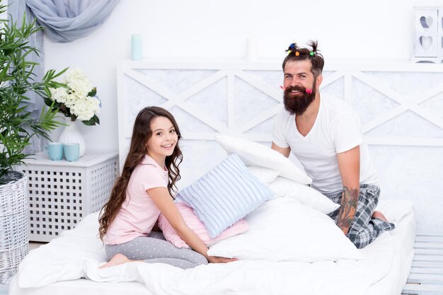 Relaxing in bedroom Being alert and sensitive to her feelings Give affection and support Happy family Role of father Sincere emotions Pajamas party Happy childhood Upbringing happy daughter