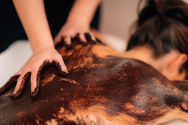 Foto massaggio rilassante alla schiena al cioccolato nel salone del benessere