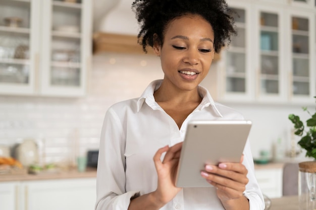 Relaxing at home at the computer replies to friends on social\
networks a woman in a white shirt works at home workplace and\
laptop a freelancer surfs the internet on a break