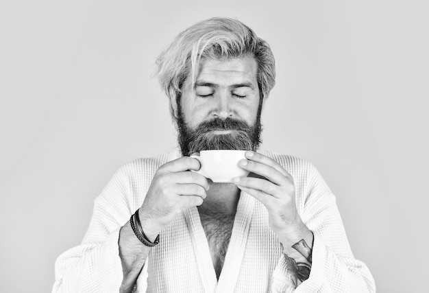 Relaxing at home drink fresh coffee beverage bearded man in bathrobe with cup coffee in bed hipster start day early awakening with cup of espresso good morning coffee need some energy charge