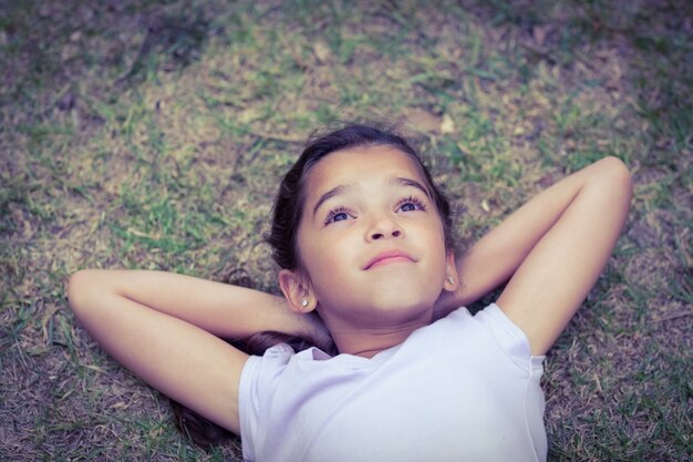 Relaxing little girl with head in the clouds