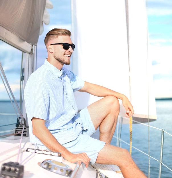 Relaxing man sitting on boat sailing on sea happy and carefree.