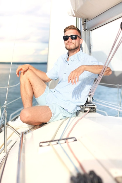 Relaxing man sitting on boat sailing on sea happy and carefree.