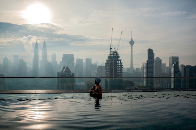 Relaxing in pool and enjoying city panorama. Kuala Lumpur, Malaysia